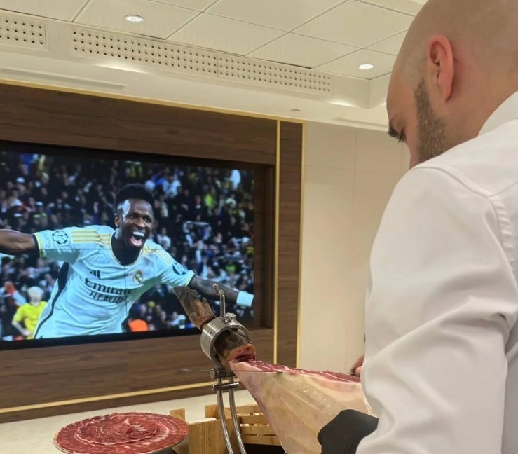 Marcos García y Alberto Izquierdo cortando jamón ibérico en un palco VIP del Santiago Bernabéu
