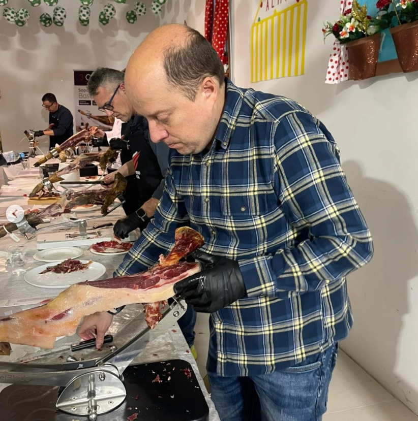 Participante cortando pieza entera de jamón ibérico durante curso de formación de GIIG en Nájera